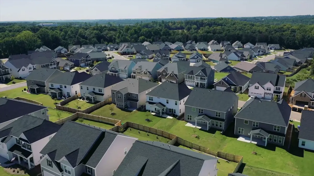 Aerial view of a finished community of new homes with fenced yards