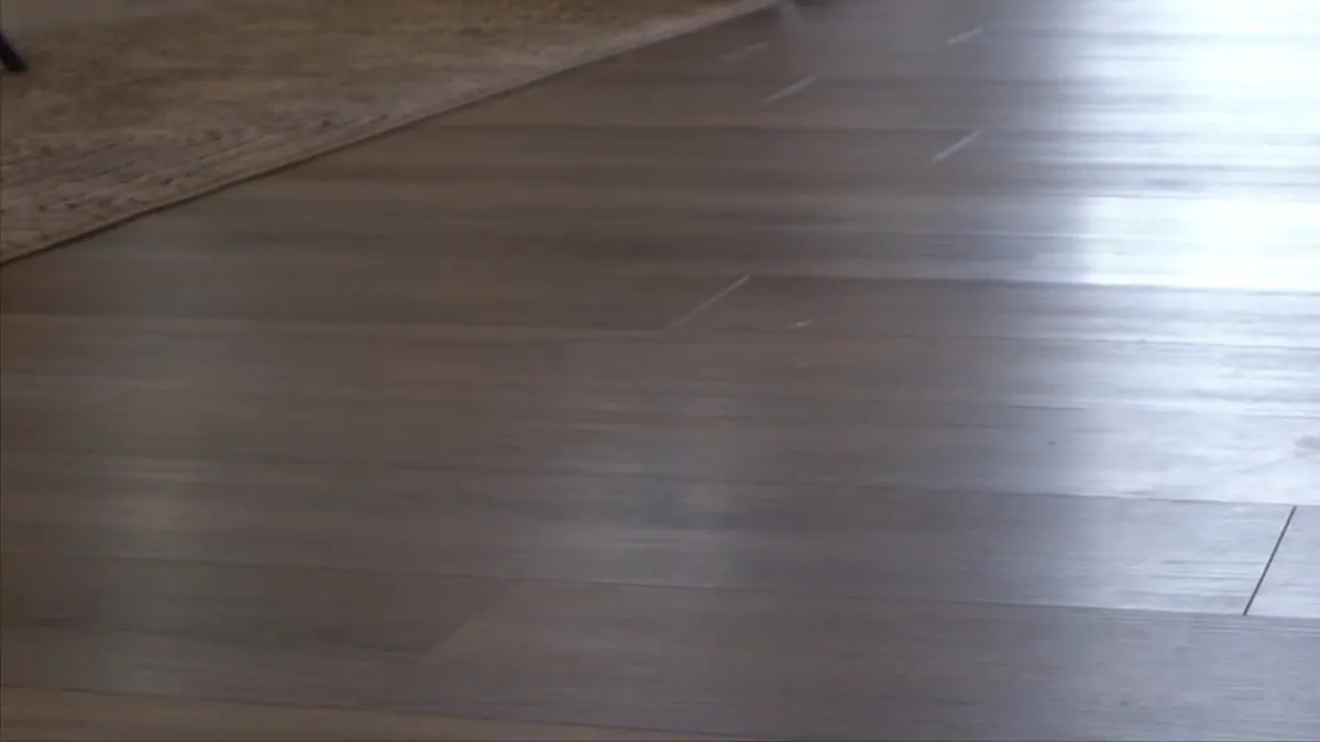 Plank flooring meeting a rug in a finished room