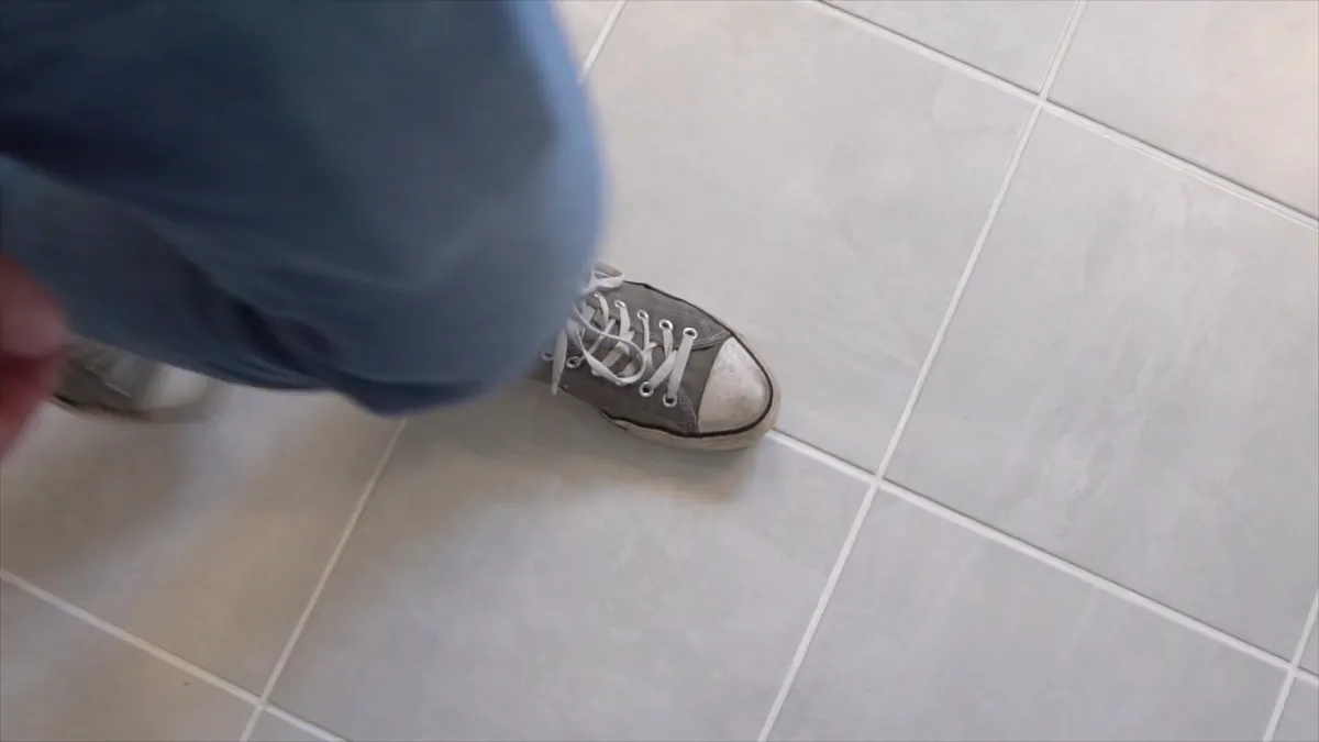 A person walking across a finished tile floor